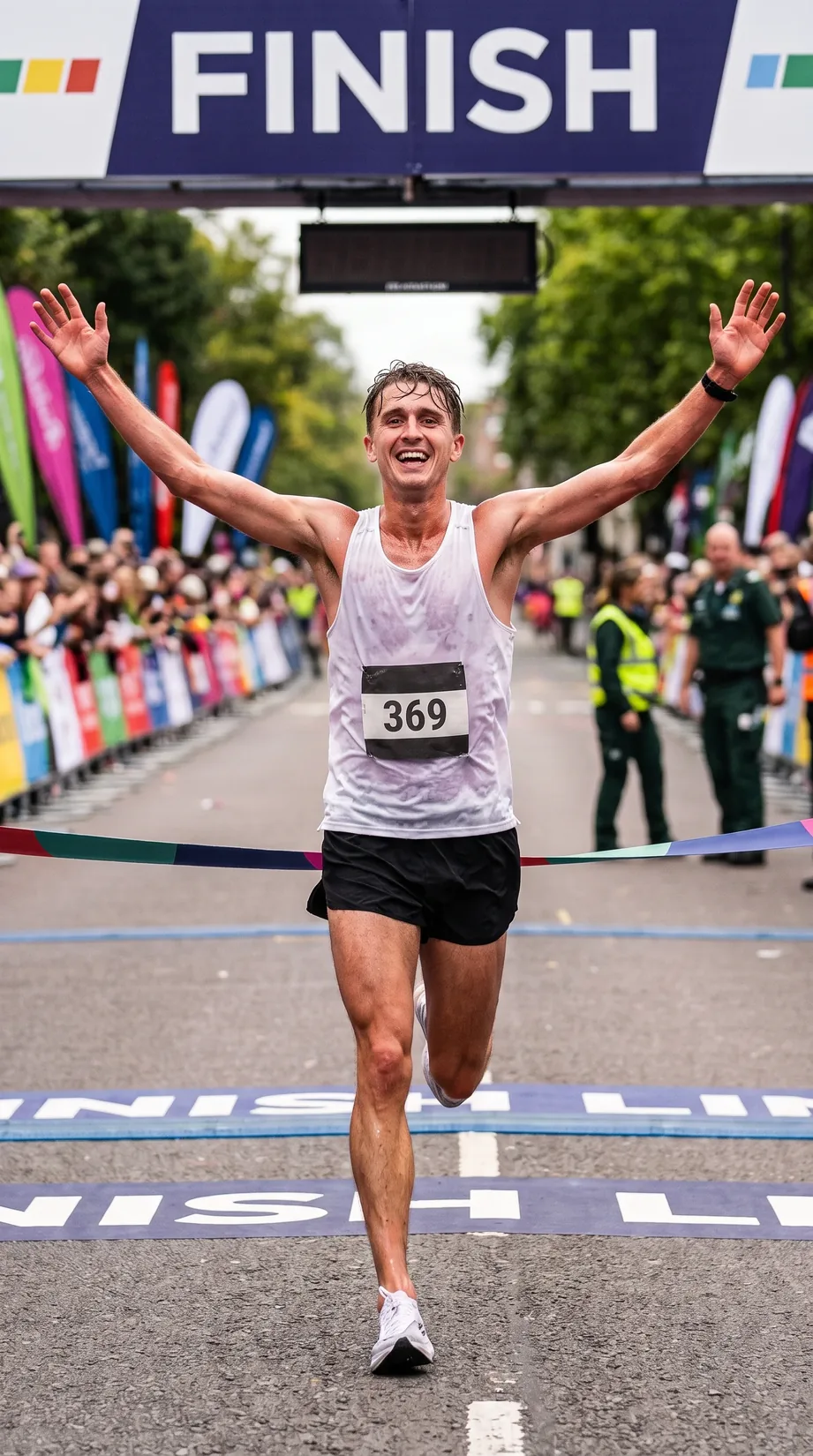 Runner celebrating beneath a marathon finish line
